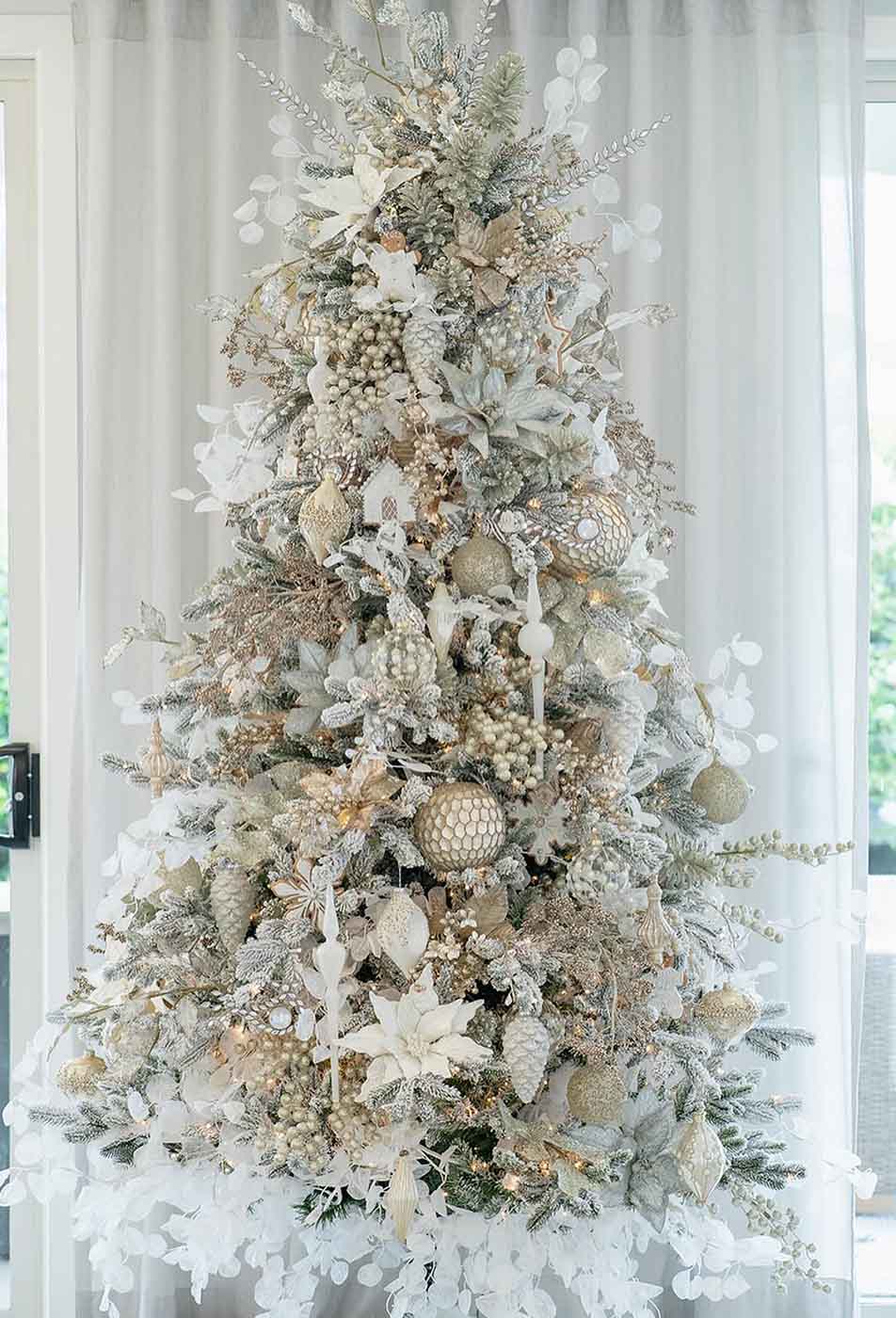 Frosted white and gold Christmas tree, adorned with champagne ornament packages, ideal for luxury christmas trees and pre dressed christmas trees.