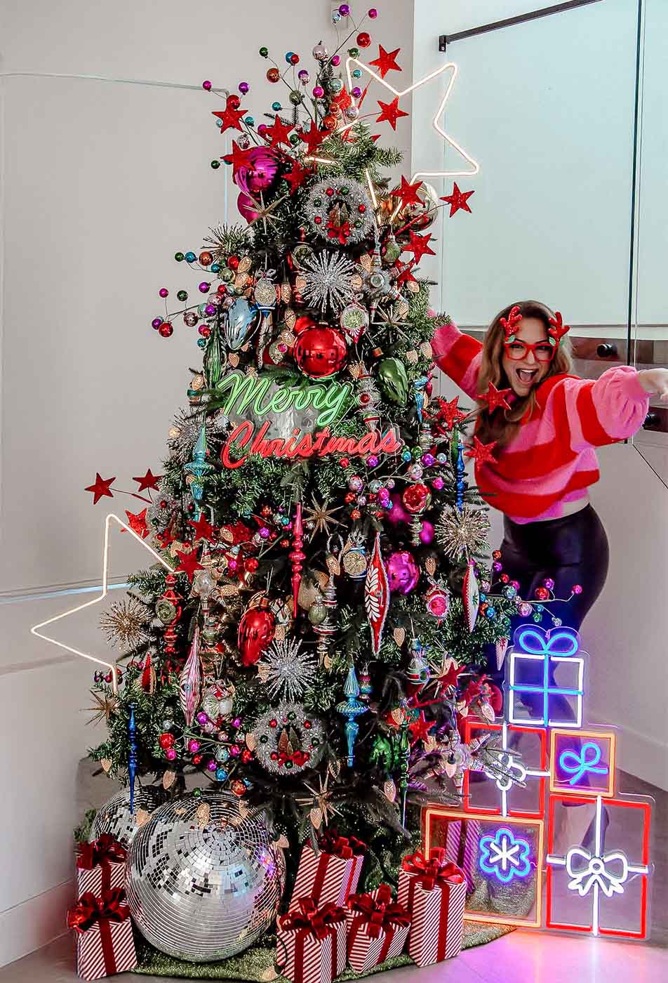 Whimsical Christmas tree with colorful ornaments, neon gift lights, and “Merry Christmas” sign, by Dancer and Dasher, Christmas stylist Sydney