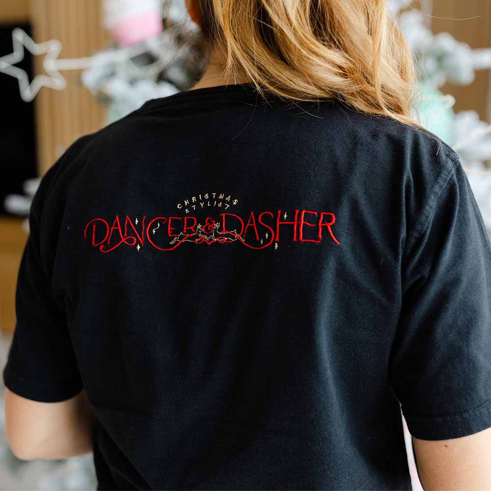 Back of woman in Dancer and Dasher branded shirt, Christmas stylist at work, interior decorators for Christmas in Sydney.